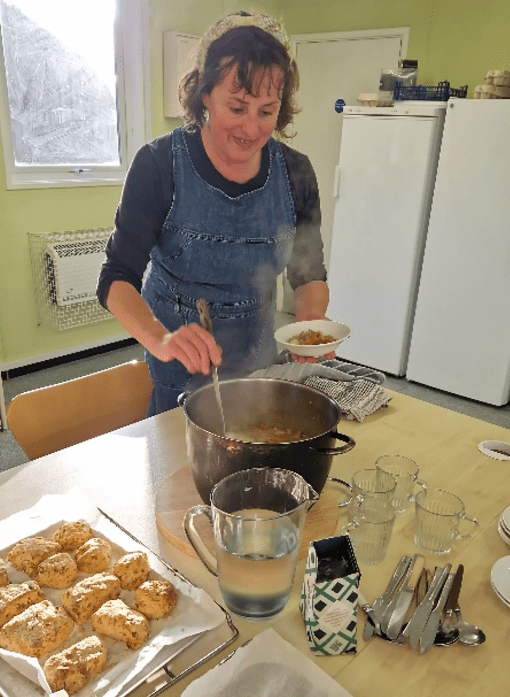 Sophia serving soup and participants chopping vegetables